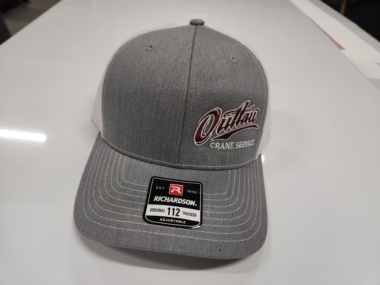 Gray Richardson 112 trucker hat with Outlaw Crane Service embroidered logo