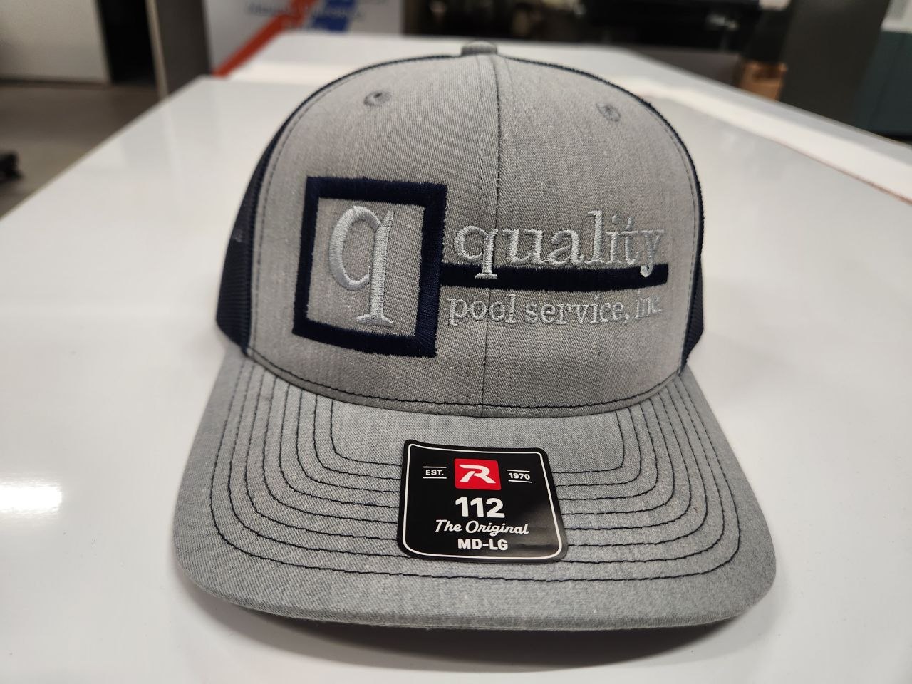 Gray Richardson 112 hat with Quality Pool Service embroidered logo