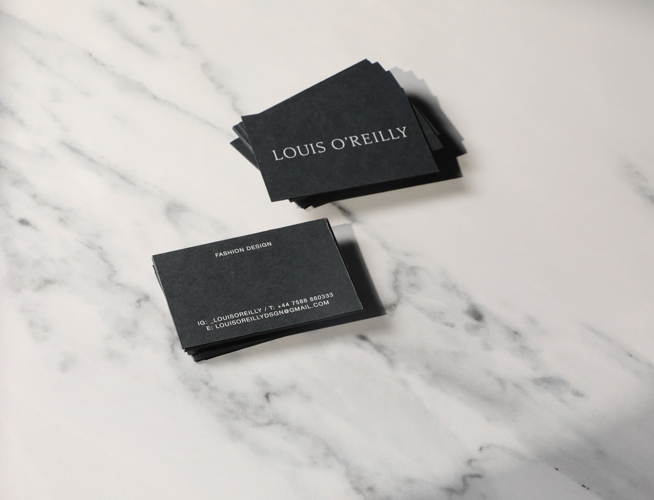 Elegant black printed business cards on marble counter