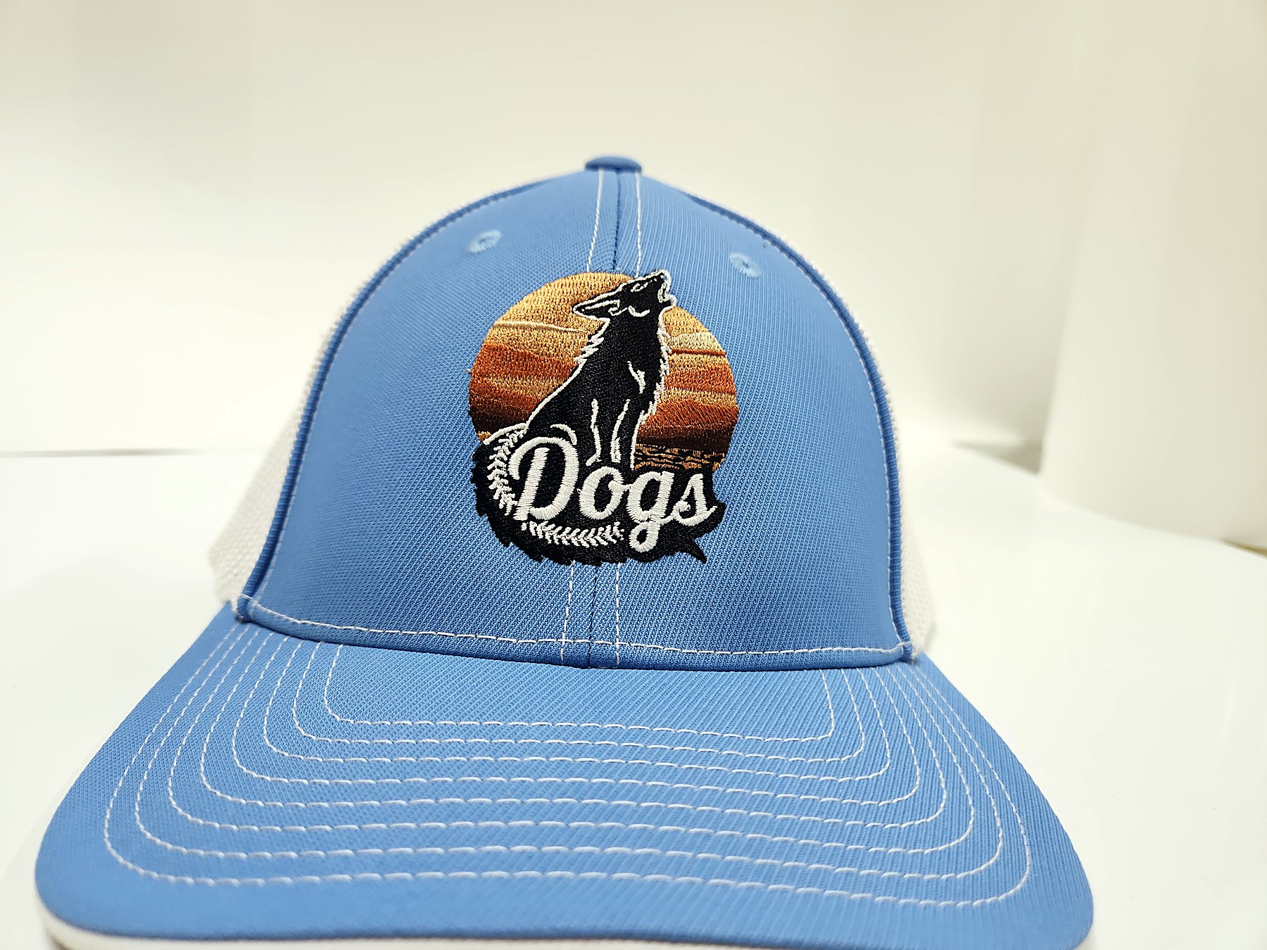 Custom embroidered howling coyote sunset 'Dogs' trucker hat by Out There Promos